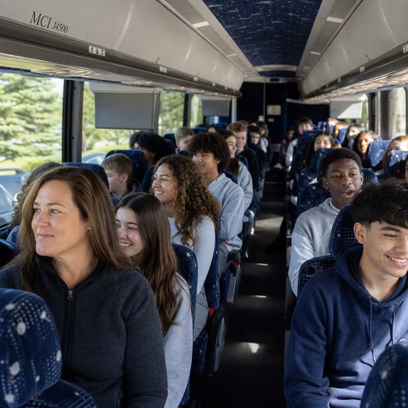 Group boarding a white charter bus for School Transportation transportation in Garden Grove