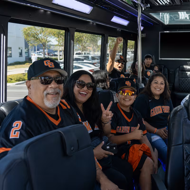 Group boarding a white charter bus for Sporting Event Transportation transportation in Garden Grove